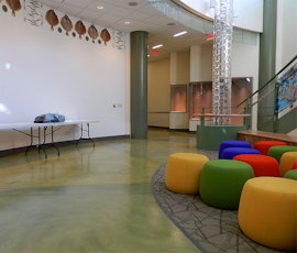 The reflections of the colorful pillow chairs and wall decor can be seen on the high-shine designer flooring. (thumbnail)